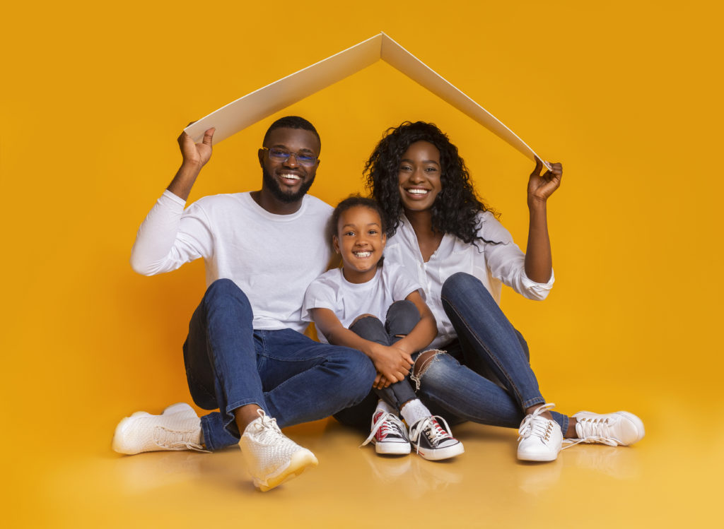 Black family of three Sitting under symbolic roof dreaming of new home
